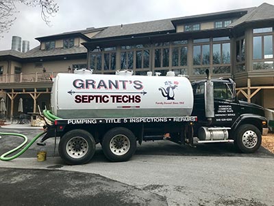 Commercial septic pumping truck and hose at a large restaurant