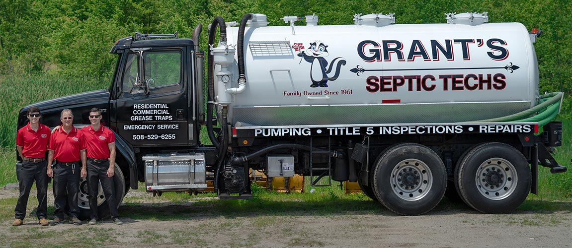 The Grants Septic Techs standing next to their septic pumping truck.