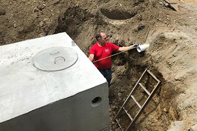 Dan Grant in the large hole measuring space around the septic tank.