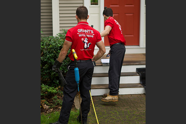 Grant’s Septic Techs carefully measure and plan the septic system repair.
