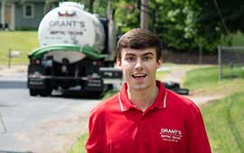 Brandon Grant, with the truck in the background, after doing septic maintenance in Holliston MA
